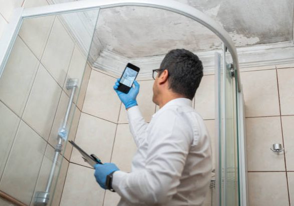 Insurance Adjuster Taking Pictures By Smartphone Of Bathroom Ceiling Damage Insurance Adjuster Taking Pictures By Smartphone Of Bathroom Ceiling Damage