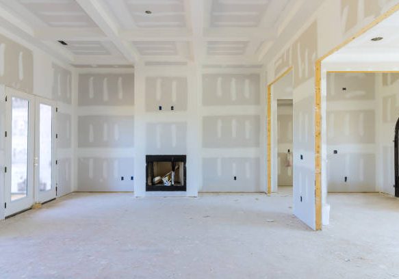 drywall To prepare the walls of a newly constructed house to be painted, finishing putty is applied to the walls of an empty apartment