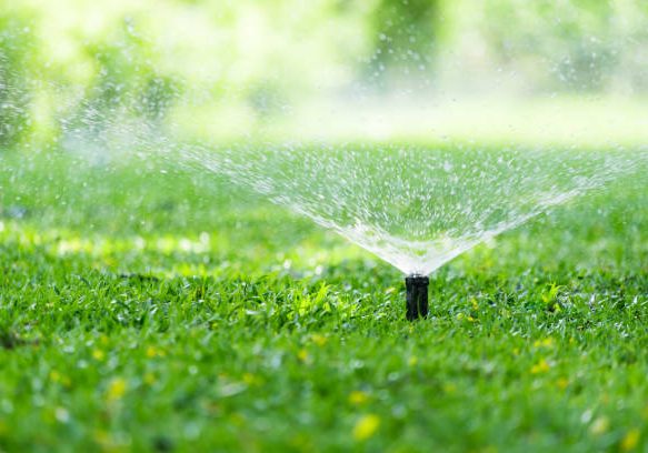 Automatic Garden Lawn sprinkler in action watering grass. Automatic Garden Lawn sprinkler in action watering grass.