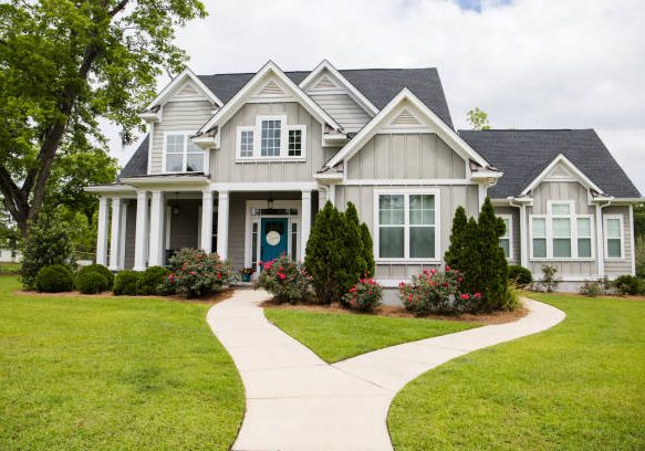 resi home This is a single family home that is new construction cottage style house with hardy board and a partial metal roof. It is grey with a teal door and there is great curb appeal. The house has a double front entrance and it is on a large lot.